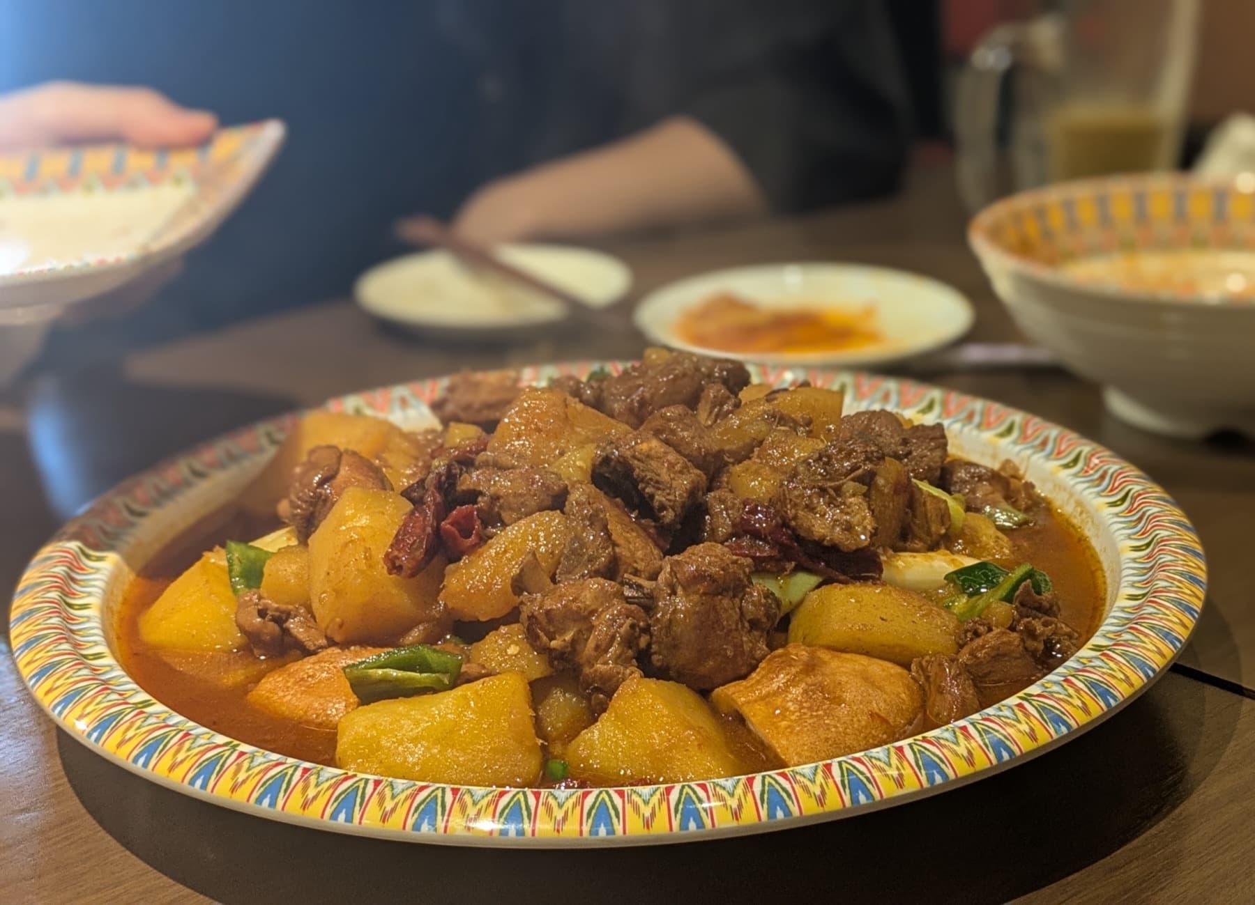 大皿で囲むウイグル料理の羊肉とじゃがいもの煮込み|旅人の交差点