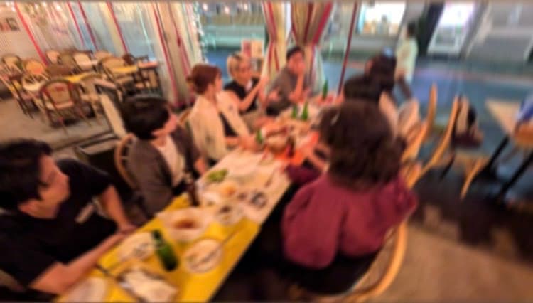 一つのテーブルに並んで談笑する参加者たち|旅人の交差点